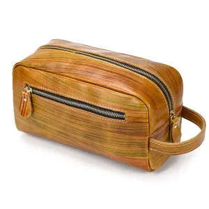 Genuine leather toiletry bag close-up showing retro texture, zipper pockets and side handle.