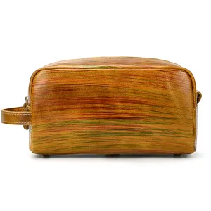 Close-up detail view of vintage genuine leather toiletry bag texture and side handle.