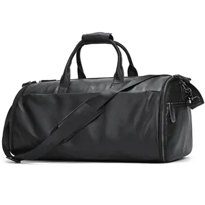 Detailed view of black leather travel duffel bag with shoulder strap and metal zippers.