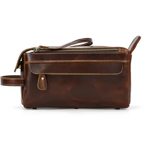 Close-up detail view of vintage genuine leather toiletry bag, retro brown texture craft.