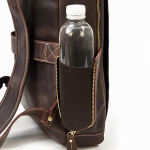 Leather backpack side pocket detail, vintage brown cowhide computer bag close-up view.