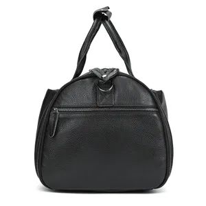 Detail shot of black leather vintage travel duffel bag showing texture, zippers, and sturdy handles.