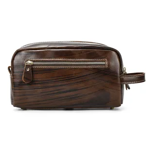 Close-up detail view of a retro dark brown leather toiletry bag featuring front zipper and side handle.