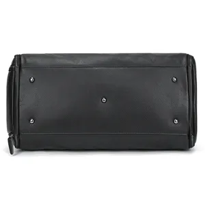 Leather travel bag bottom detail, premium black leather with metal protective feet.