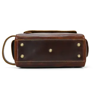 Close-up detail of the genuine crazy horse leather travel wash bag bottom with metal feet.