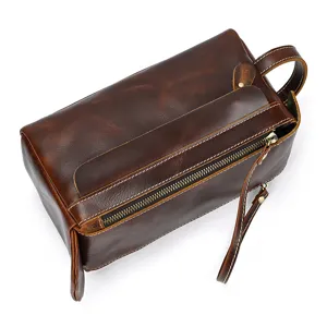 Close-up detail of dark brown genuine crazy horse leather toiletry bag zipper and handle.