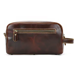 Vintage leather toiletry bag detail showing metal zipper and side handle design.