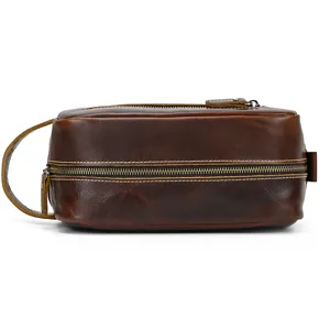 Detailed shot of brown leather toiletry bag with zipper and side handle, vintage style.