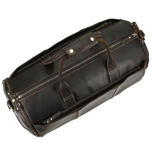 Dark brown leather travel duffel bag detail showing fine texture, stitching and zippers.