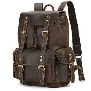 Detail view of vintage dark brown leather backpack with metal buckles and multiple front pockets.