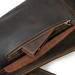 Close-up detail of dark brown crazy horse leather chest bag, showing fine stitching and metal zipper.