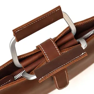 Gros plan detail de mallette homme en cuir vintage poignee metal et fermeture eclair.
