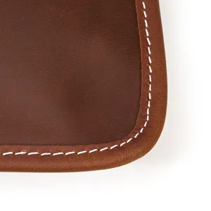 Gros plan sur le sac en cuir vintage pour homme montrant texture de vache et couture blanche.