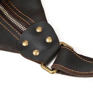 Close-up detail of vintage leather chest bag, showing sturdy hardware, rivets and neat stitching.