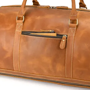 Close-up detail of vintage crazy horse leather travel duffel bag with robust zippers and handles.