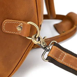 Vintage crazy horse leather travel bag hardware strap detail close up, durable metal buckle.