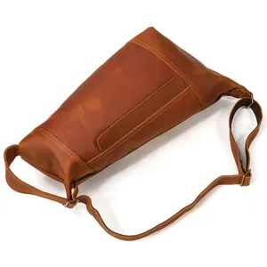 Detail view of the brown leather vintage sling bag showcasing texture and strap hardware