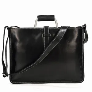 Gros plan d'un cartable d'affaires en cuir noir avec poignée métallique et coutures blanches.