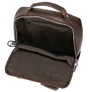 Brown leather business backpack interior detail showing USB charging port and compartment.
