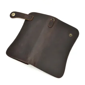 Vue détaillée du portefeuille long en cuir marron foncé avec bouton-pression métallique de qualité.