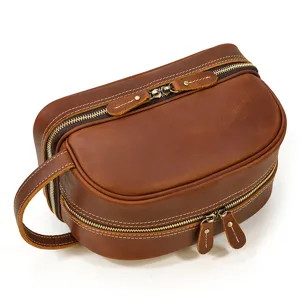Vintage brown leather toiletry bag detail showcasing double zipper and side carry handle.