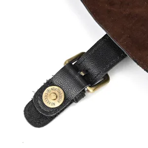 Close-up detail of black genuine leather backpack strap with vintage bronze metal buckle.