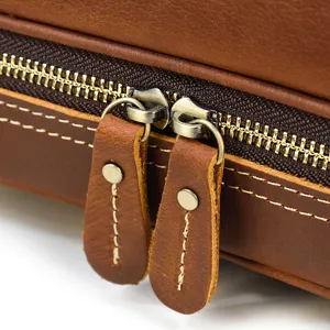 Detail shot of retro genuine leather double layer dopp kit, showing metal zipper and pull tab.