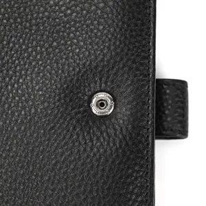 Close-up detail of black genuine leather trifold wallet snap button texture display.