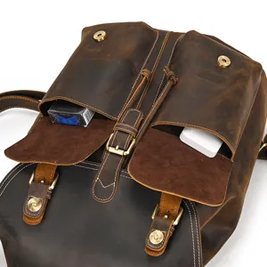 Close-up detail of vintage crazy horse leather backpack pocket and brass hardware buckle.