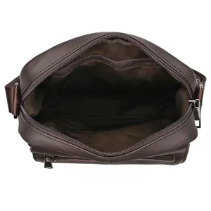 Vista de cerca del interior y forro de un bolso bandolera de cuero marrón para hombre.