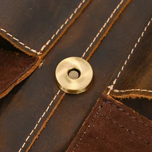 Detailed view of genuine crazy horse leather backpack with neat stitching and metal snap.