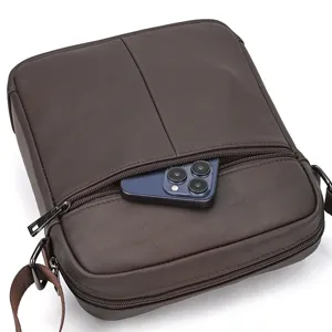 Vista detallada del bolso cruzado de cuero marron para hombre con bolsillo delantero.