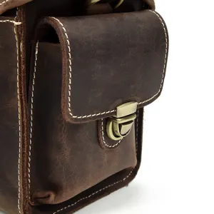 Dettaglio in primo piano della borsa per fotocamera in pelle vintage con serratura in ottone.