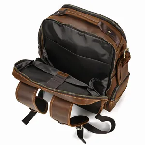 Close-up detail view of interior storage compartments on vintage brown leather men's backpack.