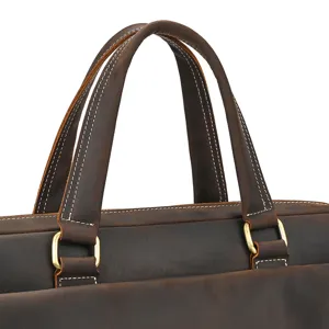 Close-up of vintage crazy horse leather briefcase handle with durable stitching and hardware.