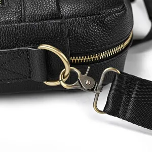 Men's leather bag detail shot featuring genuine cowhide texture and vintage brass hardware.