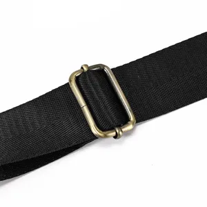Close-up of black bag strap and metal adjuster buckle detail for men briefcase.