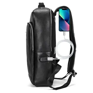 Side detail view of black leather business backpack with built-in USB charging port.