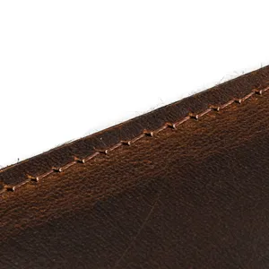 Close-up detail of retro genuine leather wallet showing fine hand stitching and natural vintage texture.