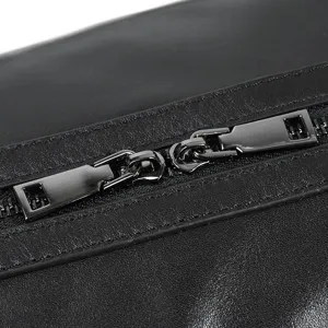 Close-up detail of leather travel bag zipper, premium dark hardware and fine texture.