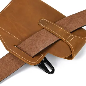 Close-up detail of vintage crazy horse leather phone holster with belt loop and metal hook.