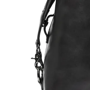 Close-up detail of black leather bag strap hardware metal clasp and durable ring buckle.