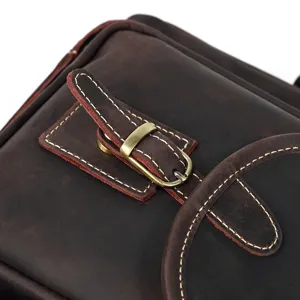 Close-up detail of vintage crazy horse leather bag, durable brass buckle and contrast stitching.