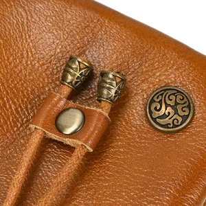 Detailed close-up of retro vegetable-tanned leather coin purse with bronze metal hardware.