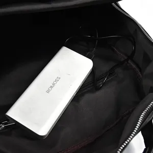 Men's leather laptop backpack interior detail showing USB charging port and slot.