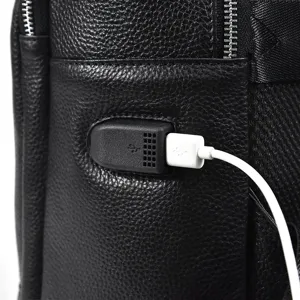 Close-up detail of black leather backpack featuring a convenient external USB charging port.