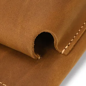Macro detail shot showing genuine crazy horse leather texture and precise edge stitching.