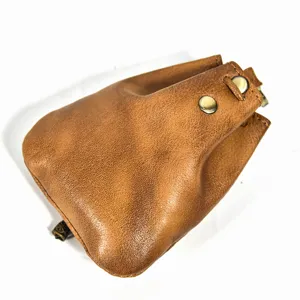 Brown leather squeeze coin purse detail shot, vintage mini wallet with metal snap closure.