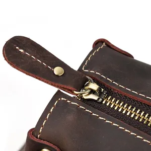 Close-up detail of men vintage crazy horse leather bag zipper and robust stitching texture.