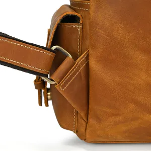 Close up detail of vintage crazy horse leather backpack strap and metal hardware texture